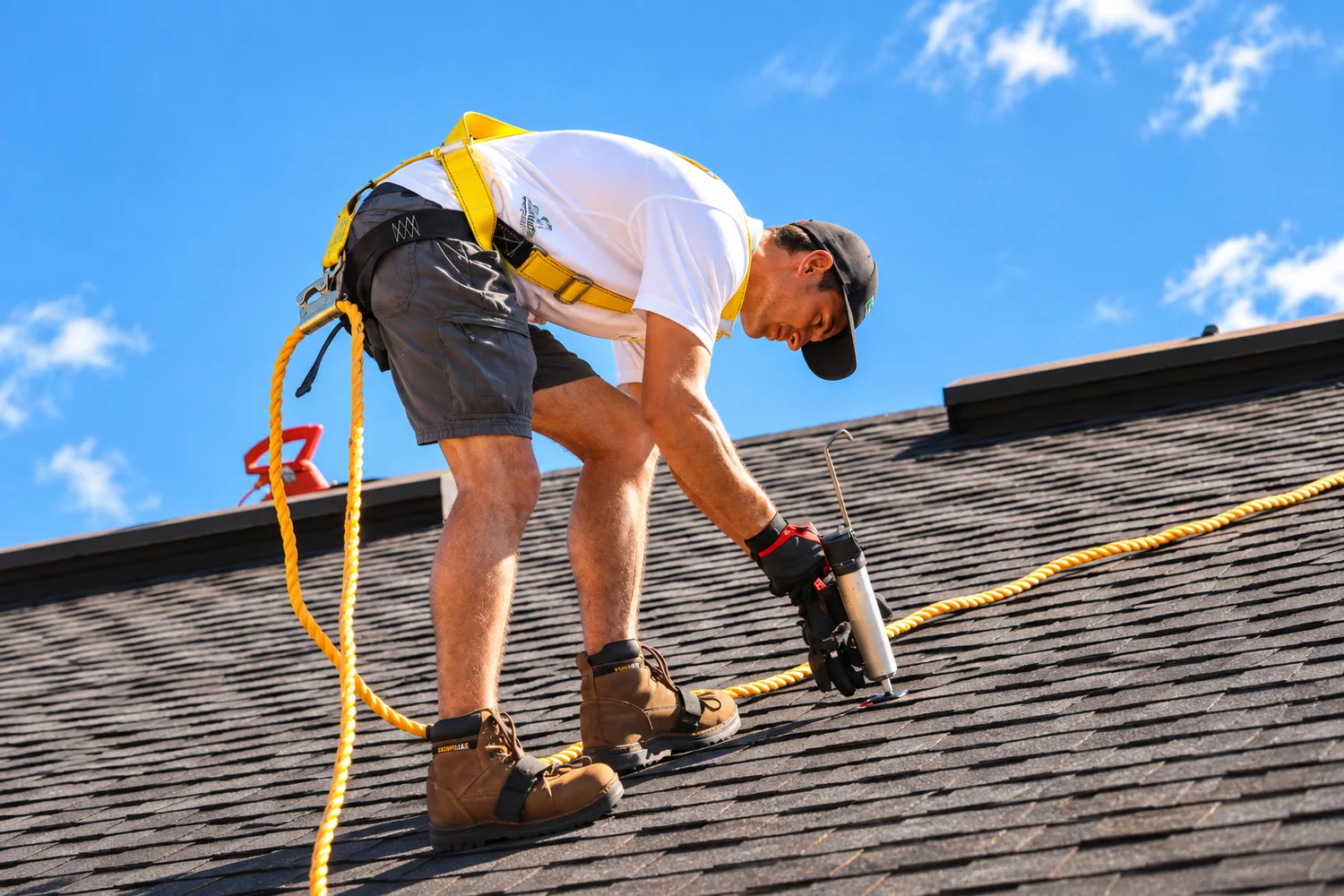 Roofer carefully fastening architectural shingles